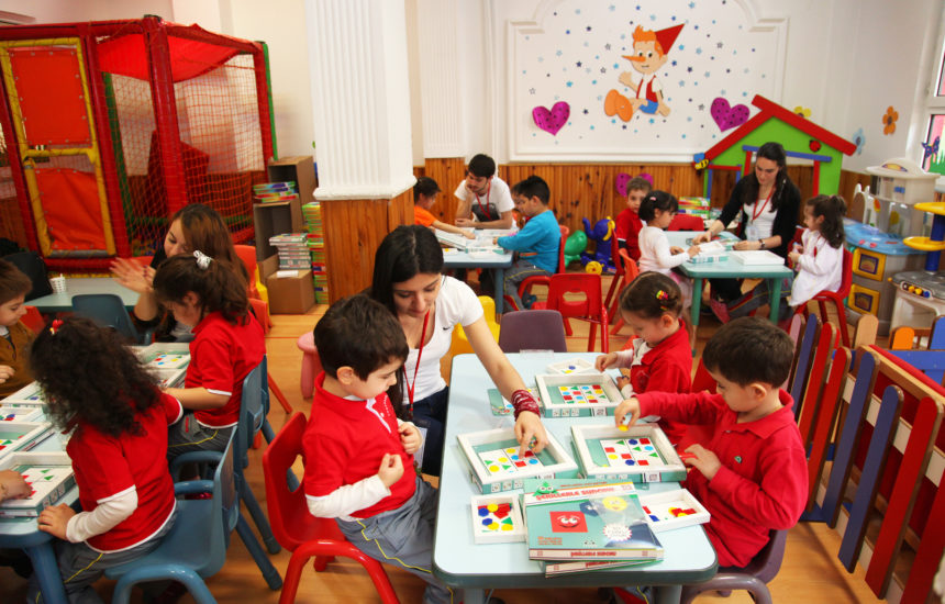 Children in a classroom learning with support from teachers
