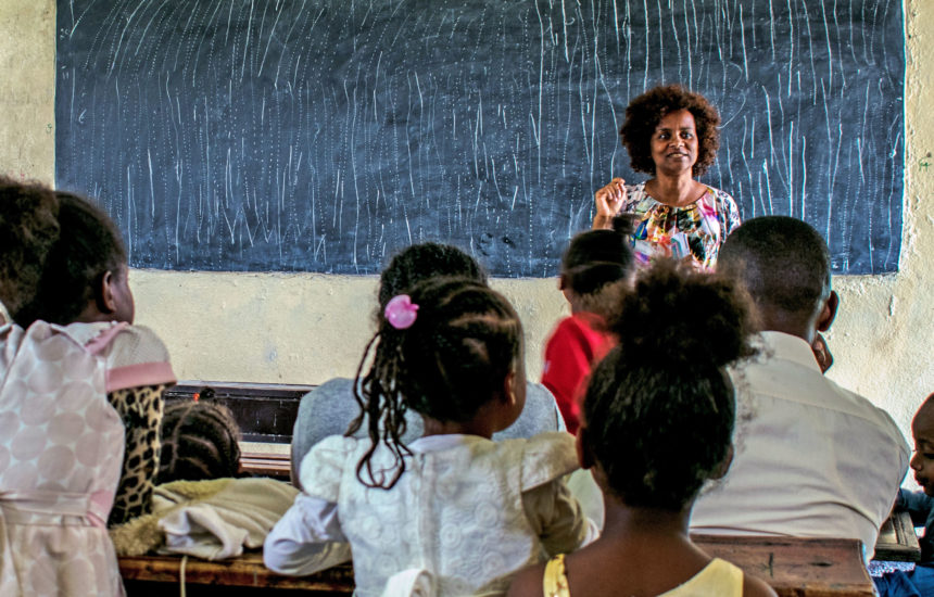 A woman teaches to children in a classroom