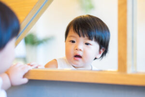 Child looking in mirror.