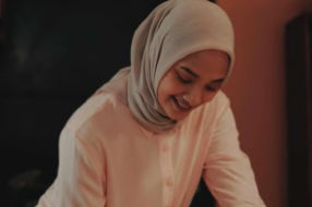 A woman smiles and writes in a journal