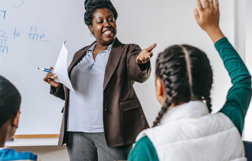 Photo of a teacher calling on a student with her hand raised