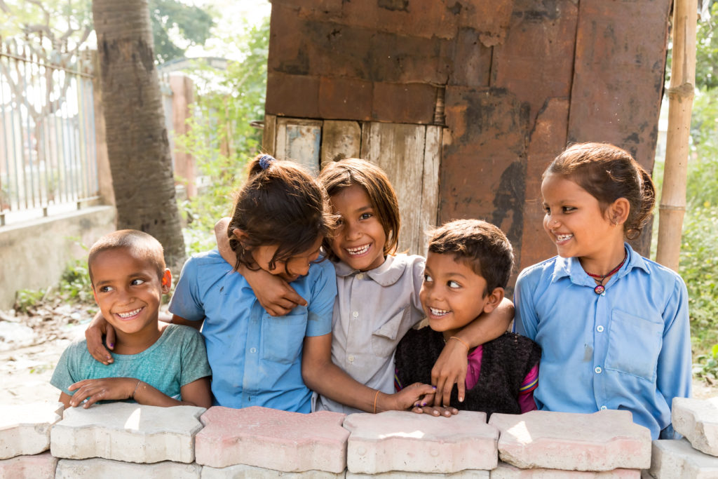 A group of five young children happily standing together, showcasing the power of Education Diplomacy.