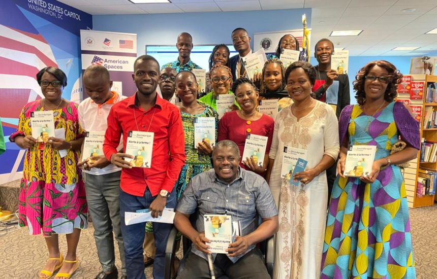 Group of smiling educators in Cote d'Ivoire, holding certificates from the training they completed.