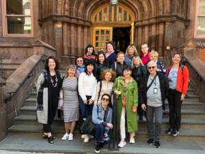 Group of people standing on stairs of building.