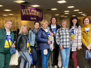 Eight people smile for photo inside building