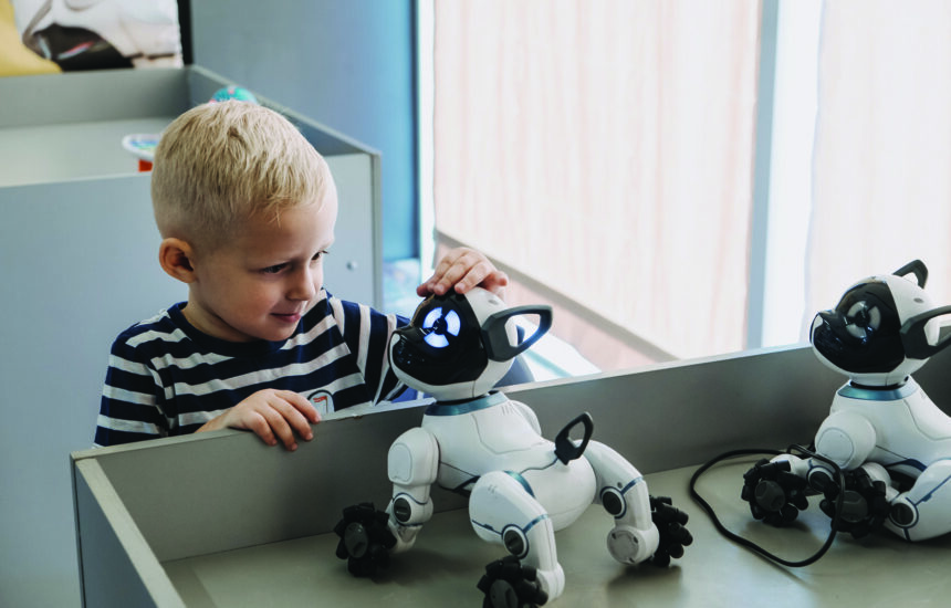 Little boy playing with interactive Remote Control Robot Dog Toy.