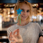 Headshot of Svitlana Tarasonva, a Ukrainian Project Fellow. In the photo, she is holding up a blue star and smiling