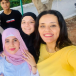Headshot of Yanal Mouusa, a QHPLL Project Fellow in Lebanon. In the photo, she is standing with several of her students