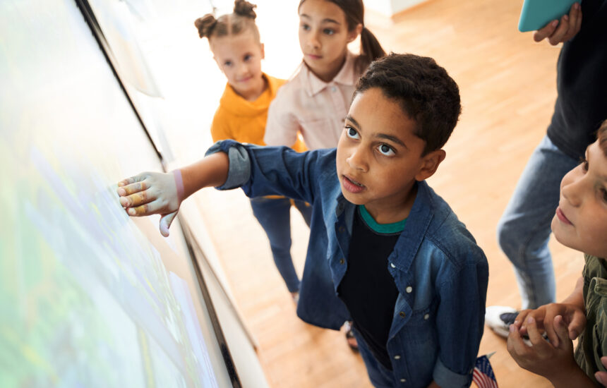 A boy touches an interactive whiteboard