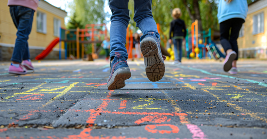 Kids playing hopscotch outdoors at recess.