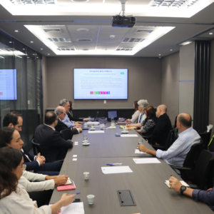 A group of team members from FADC and CE International sitting around a table together.