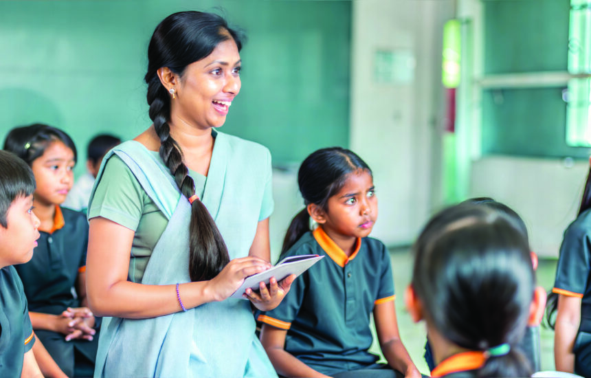 A smiling teacher with students in her classroom.