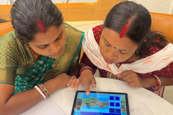 Two program coaches reviewing the Coach Up app on a tablet.