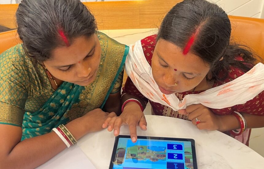 Two program coaches reviewing the Coach Up app on a tablet.