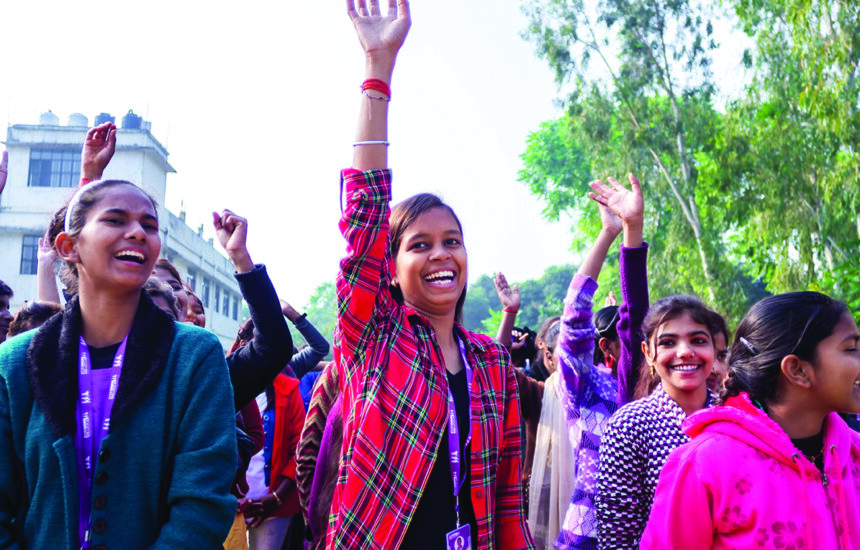 A photo of girls holding their arms in the air.